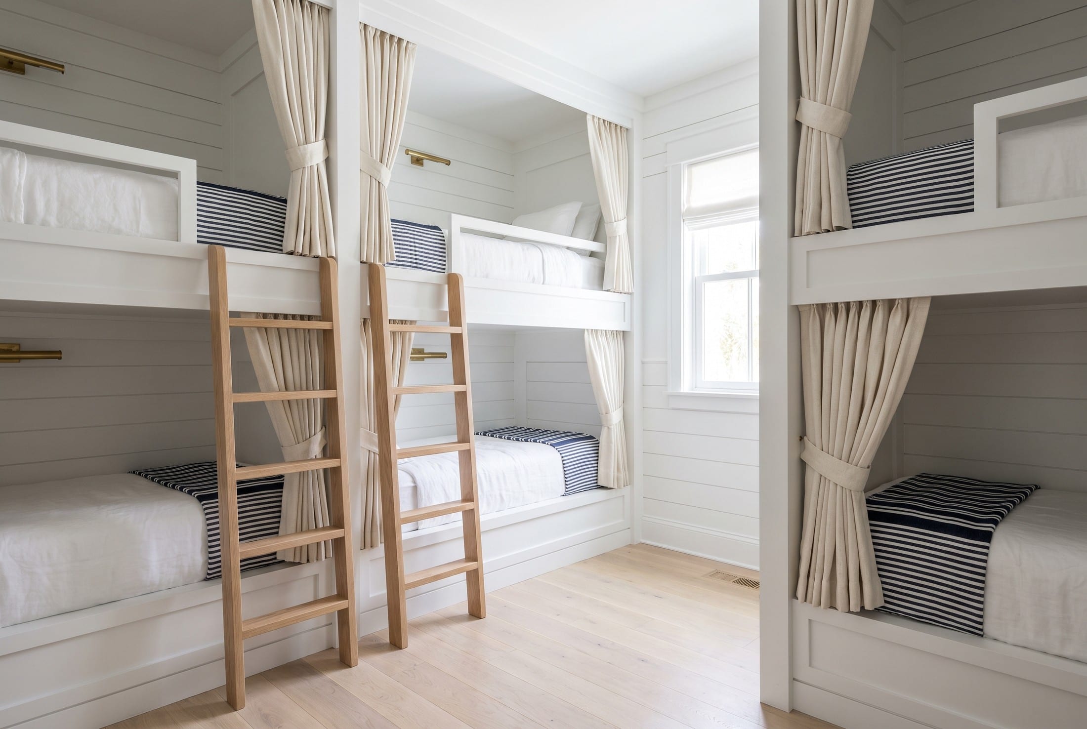 A custom bunk room in a Florida beach house with every berth made and staged.